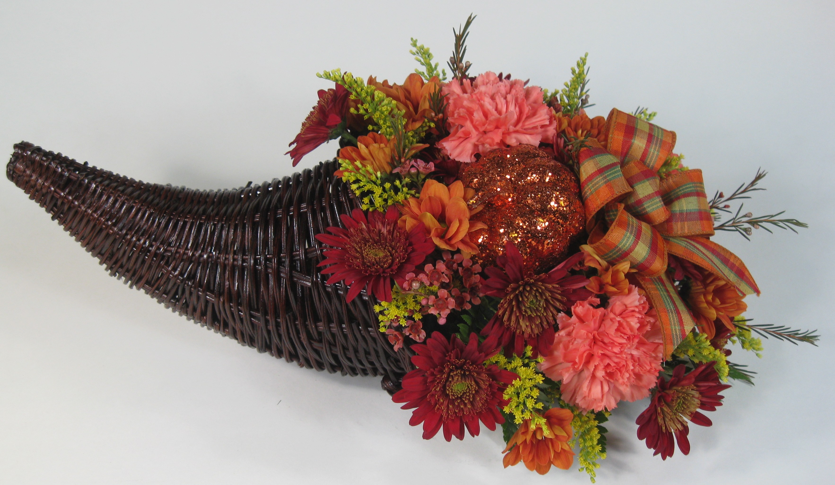 Create a Thanksgiving table setting around this Horn of Plenty. Pick from a variety of our Fall ribbons and colourful assorted arrangement of Autumn flowers.